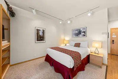 a bedroom with a bed and a dresser and a tv at Palisades Tahoe Lodge Rentals Studio #253 in Olympic Valley