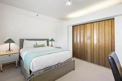 a bedroom with a large bed and a wooden closet at Palisades Tahoe Lodge Rentals Studio #254 in Olympic Valley