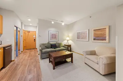 a living room with a couch and a table at Palisades Tahoe Lodge Rentals Studio #256 in Olympic Valley