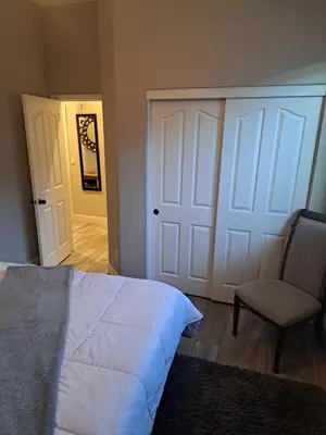 a bedroom with a bed and a chair and a door at Roseville Properties in Roseville