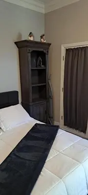 a bedroom with a bed and a shelf with two birds on it at Roseville Properties in Roseville
