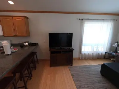 a living room with a flat screen tv and a kitchen at Rr-johnson Suite in June Lake