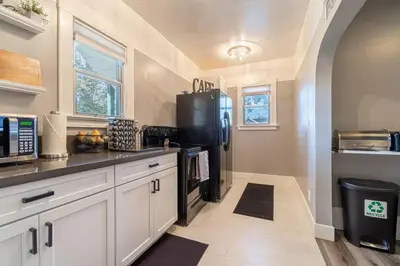 a kitchen with white cabinets and a black refrigerator at Rustic 3-Bedroom, 1.5-Bath Oasis by Downtown in Reno