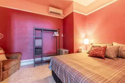 a red bedroom with a bed and a chair at Rustic 3-Bedroom, 1.5-Bath Oasis by Downtown in Reno
