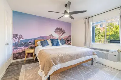 a bedroom with a bed with a painting on the wall at Midtown Modern - Stylish 2BR Lodging in Reno in Reno