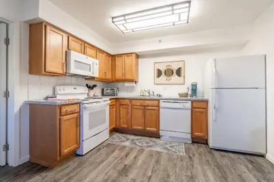 a kitchen with white appliances and wooden cabinets at Midtown Modern - Stylish 2BR Lodging in Reno in Reno