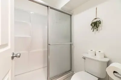 a white bathroom with a shower and a toilet at Modern Haven: Chic Studio Getaway in Reno