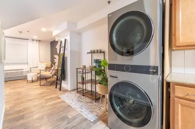 a washing machine in a kitchen with a living room at Stylish-Serene Midtown Getaway: Retreat for Two in Reno