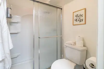 a bathroom with a toilet and a glass shower at Midtown Getaway: Trendy Studio Heart of Reno in Reno