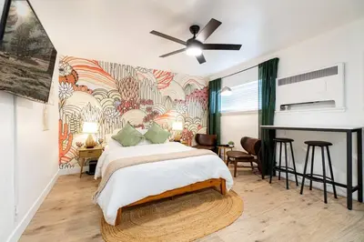 a bedroom with a bed and a wall mural at Riverside Glam: Stylish Urban Escape in Reno