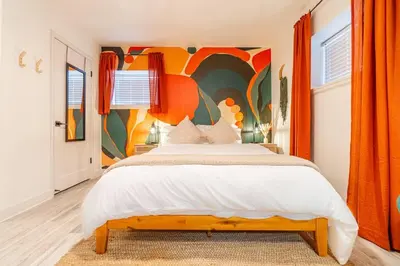 a bedroom with a large bed with a colorful wall at Riverside Luxe: Stylish Designer Retreat in Reno