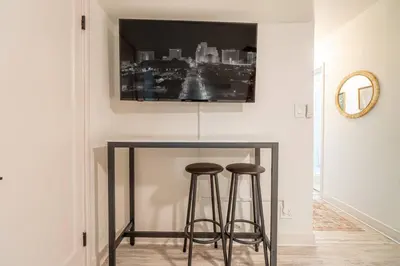 a table with two bar stools and a tv on the wall at Riverside Luxe: Stylish Designer Retreat in Reno