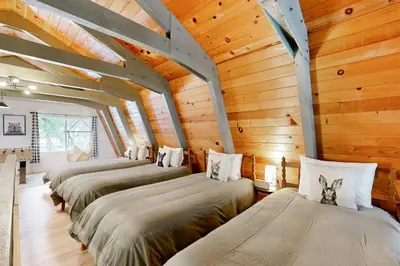 a row of beds in a room with wooden walls at Groovy Days Chalet in Arnold