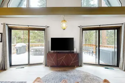a living room with a tv and sliding glass doors at Groovy Days Chalet in Arnold