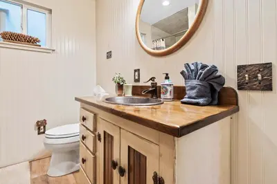 a bathroom with a sink and a mirror at Lewis Creek cabin near Yosemite king beds in Oakhurst