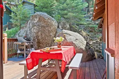 a table with a red table cloth on a deck at Sugar Pine cabin in the woods King bed Fire pit in Oakhurst