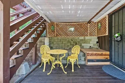 a patio with a table and chairs and a bench at Sugar Pine cabin in the woods King bed Fire pit in Oakhurst
