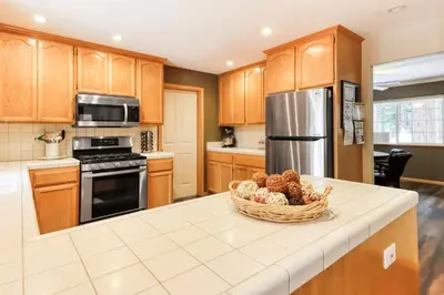 a kitchen with wooden cabinets and a basket of fruit on a counter at Gentian Family Retreat in South Lake Tahoe