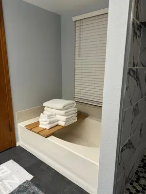 a bathroom with a bath tub with towels on a shelf at Meadow Landing in Three Rivers