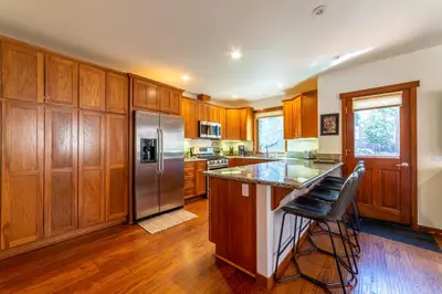 a kitchen with wooden cabinets and a stainless steel refrigerator at Luxury home close to Village; Garage & Jacuzzi in Mammoth Lakes