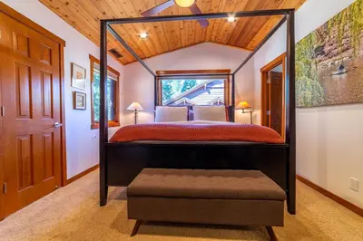 a bedroom with a four poster bed and a window at Luxury home close to Village; Garage & Jacuzzi in Mammoth Lakes