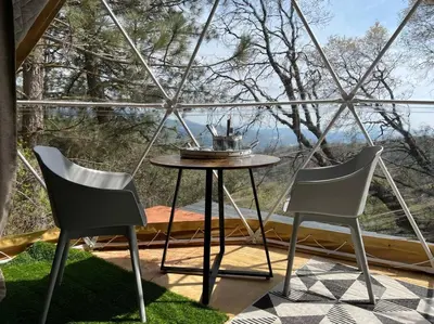 two chairs and a table in front of a window at Glamping Dome 1 - 10 minutes from Kings Canyon in Dunlap