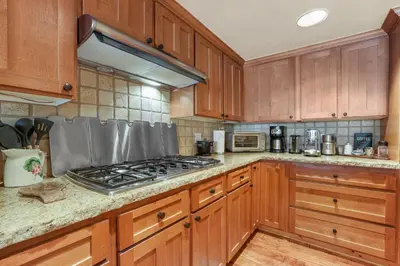 a kitchen with wooden cabinets and a stove top oven at Lavishness at Elevation – Timber Ridge 3 Bedroom condo in Kirkwood