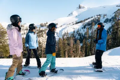 a group of people on snowboards on a snow covered slope at Luxury at Altitude – Base Camp 2 Bedroom condo in Kirkwood