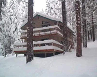 a building covered in snow in the woods at Sweet Retreat: Theater, Pool/Ping-Pong, Quiet! in Camp Connell