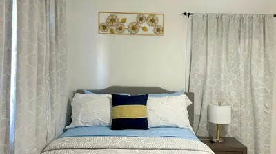 a bedroom with a bed with blue and white pillows at Beautiful Spanish-Styled Home in Fresno