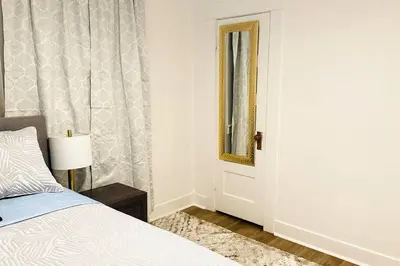 a bedroom with a bed and a mirror and a window at Beautiful Spanish-Styled Home in Fresno