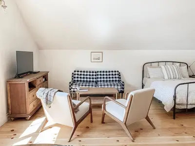 a living room with two chairs and a bed at Homestead Barn Loft in Sonora