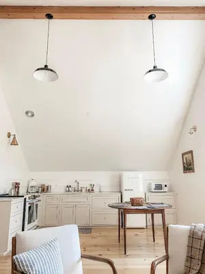 a kitchen with white cabinets and a table at Homestead Barn Loft in Sonora