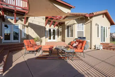 a patio with chairs and a table and an umbrella at Balcony Suite Fraser Family Vineyard Stay in Amador in Plymouth