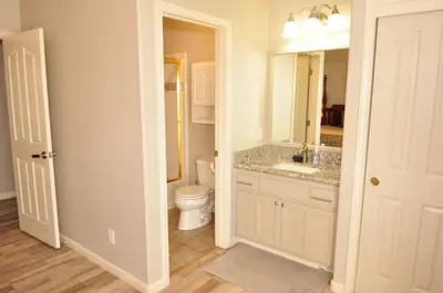a bathroom with a toilet and a sink and a mirror at Balcony Suite Fraser Family Vineyard Stay in Amador in Plymouth