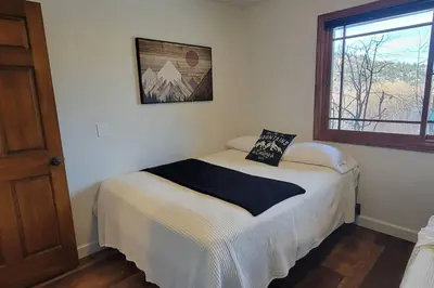 a bedroom with a bed in a room with a window at Lakefront Mountain Retreat in June Lake