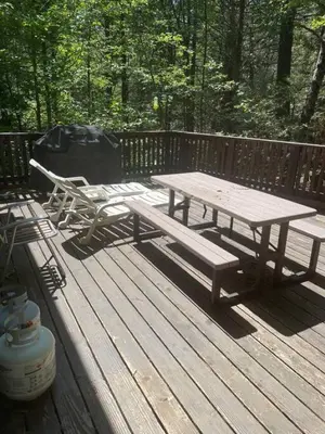 a picnic table and a bench on a wooden deck at Big Cabin on the Creek in Camp Connell