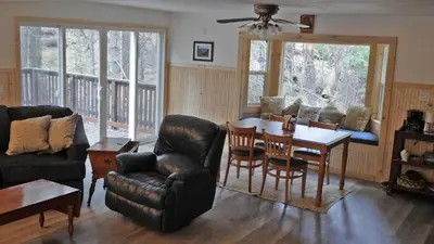 a living room with a table and a dining room at Big Cabin on the Creek in Camp Connell