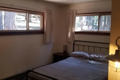 a bedroom with a bed and two windows at Mountain Life On Deck in Arnold