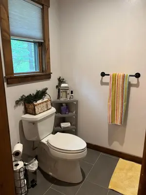 a bathroom with a white toilet and a window at Cabin in the Woods in Tahoe Vista