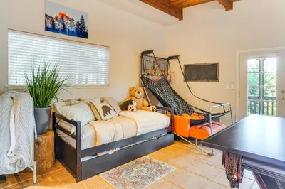 a childs bedroom with a bed and a table at Enchanted Woodland Cabin Near Yosemite with Fire Pit in Groveland