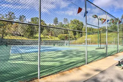 a tennis court with a net on a tennis court at Enchanted Woodland Cabin Near Yosemite with Fire Pit in Groveland