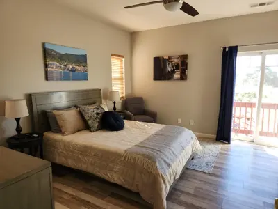 a bedroom with a bed and a chair and a window at Balcony Suite 2 Fraser Family Vineyard Stay in Amador in Plymouth