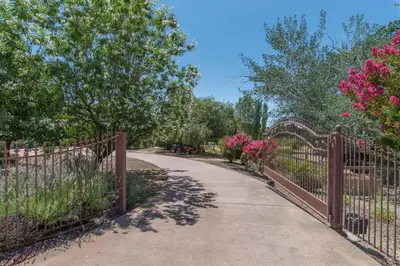 a walkway through a fence with pink flowers at Balcony Suite 2 Fraser Family Vineyard Stay in Amador in Plymouth