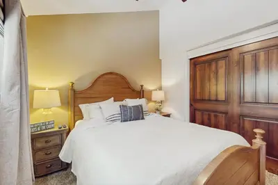 a bedroom with a large white bed with a wooden headboard at High Sierra Haven in Incline Village