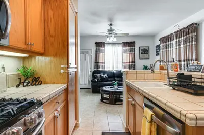 a kitchen and living room with a stove top oven at Spacious Turlock Home about 1 Mi to University! in Turlock