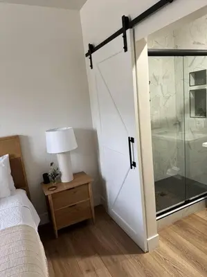 a bedroom with a sliding glass door leading to a shower at Soleil Luna 2 miles from Sequoia Park Entrance in Three Rivers