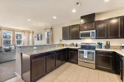 a kitchen with wooden cabinets and a stove top oven at MidTown Hideaway Fire Pit and King Beds in Reno