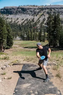 a man playing with a frisbee in a field at Sierra Cabin Condo – Sun Meadows 1 BedroomLoft condo in Kirkwood