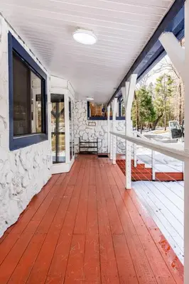 a porch of a house with a wooden floor at Modern LakeHouse Sleeps 20 Hot Tub/Games/Fire Pit in Oakhurst